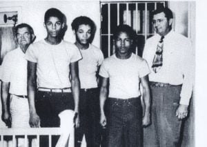 Black and white photo of the Groveland Four, with jailer at left and Sheriff McCall at right