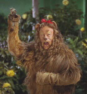 From the Wizard of Oz movie, image of the Cowardly Lion raising his arm above his head while his mouth is open, looking like he is lecturing.