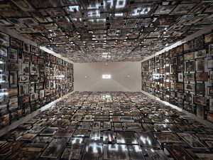 Stretching up up up to a ceiling far above, four walls are covered in lovingly framed photos of European Jewish families before the Holocaust.