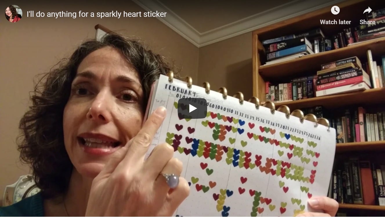 The author holding up her tracking sheet with heart stickers on it